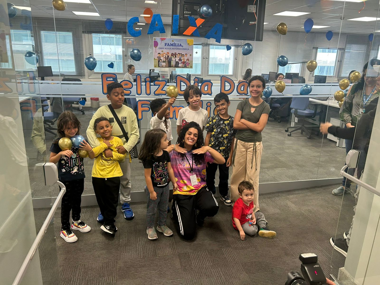 Uma recreadora junta de várias crianças sorridentes posada para a camera